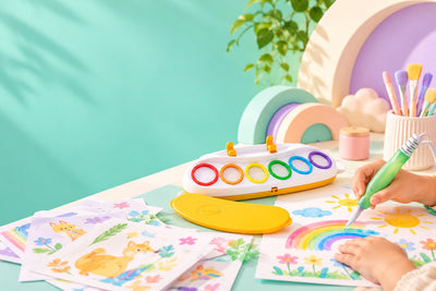 Magic Light Brush art set on a mint and lilac table, with a child painting a rainbow.